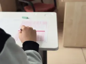 Nahaufnahme eines Schülers, der in einer Unterrichtsumgebung einen Test beantwortet.
